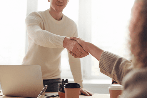 An insurance agent shaking hands with a client.