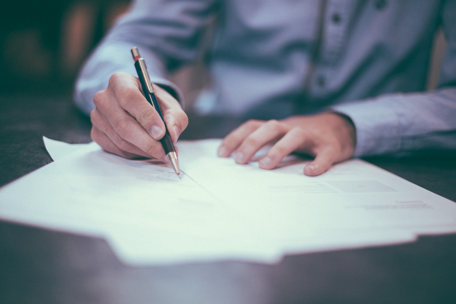 Man writing on paper for voluntary insurance