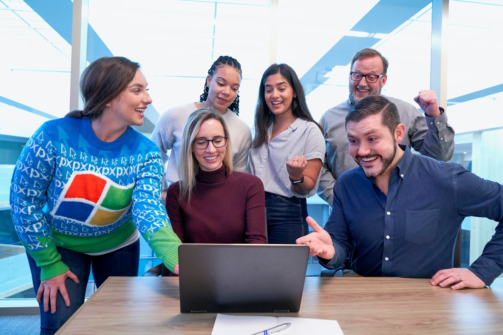 woman in maroon sweater using laptop explaining Employment Practices Liability Insurance